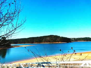 Scenic view of lake against clear blue sky