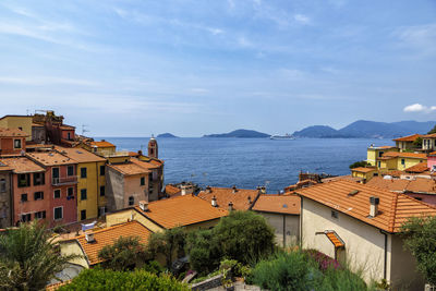 High angle view of buildings by sea against sky