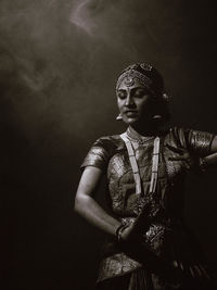 Portrait of woman standing against wall