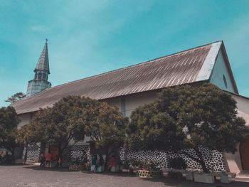 Low angle view of house and church against sky