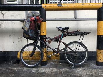 Bicycle parked on footpath against wall