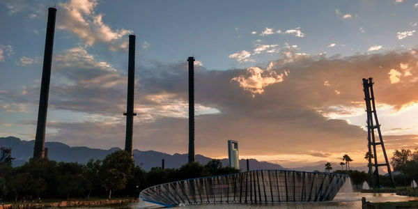 Panoramic view of factory against sky during sunset