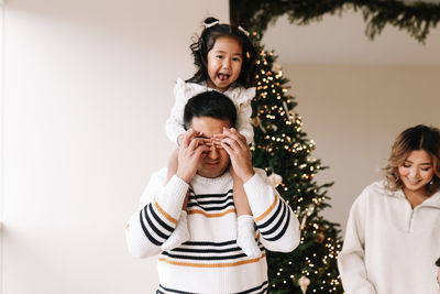 Asian multi-racial family with two children celebrate christmas holiday in decorated indoor house
