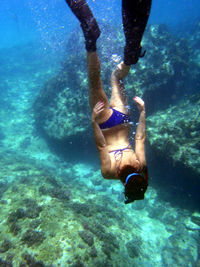 Low section of young woman swimming in sea