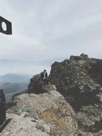 Man on rock against sky