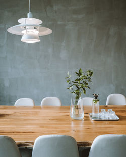 Table and chairs in vase against wall at home