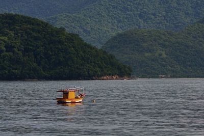 Boat in river against mountains