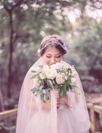 Smiling bride holding bouquet