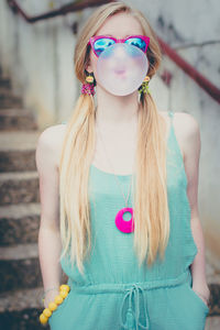 Beautiful young woman blowing up a gum like a baloon