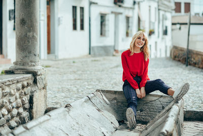 Portrait of smiling young woman sitting outdoors