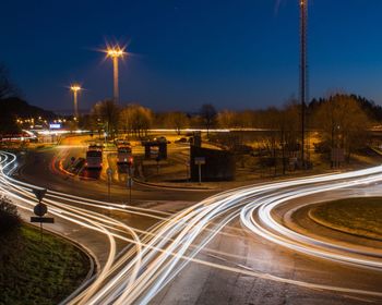 Light trails on road against sky at night