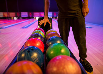 Low section of man with lots of bowling balls 