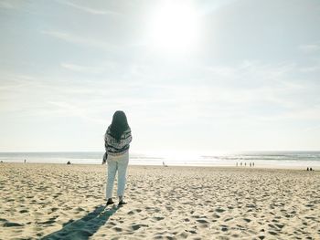 Rear view of woman walking on beach