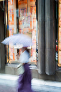 Blurred motion of woman walking on street in city