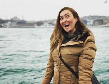 Woman with mouth open against river