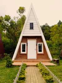 Exterior of house by building against sky