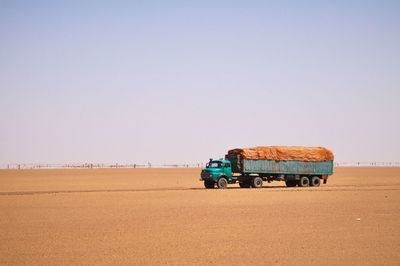 Tractor on road against clear sky