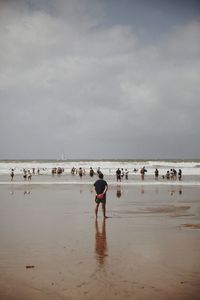 People at beach against sky