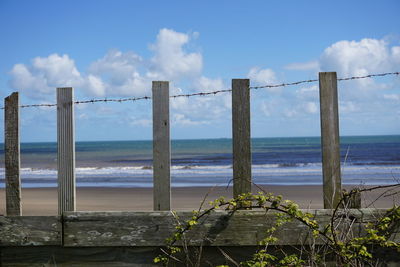 Scenic view of beach seen through fence