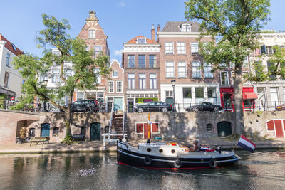 Boats in canal by buildings in city