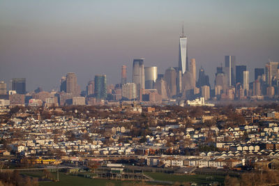 Freedom tower and lower manhattan seen behind a new jersey suburb.