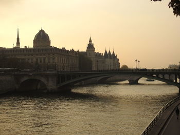 Bridge over river in city against clear sky