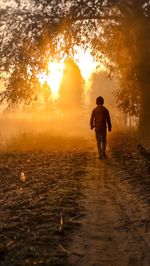 Silhouette man walking on street against sky during sunset