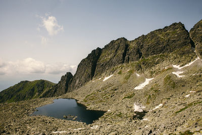 Scenic view of rocks by sea against sky