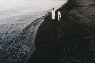 High angle view of couple walking on beach