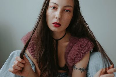 Sad woman with pink makeup at home