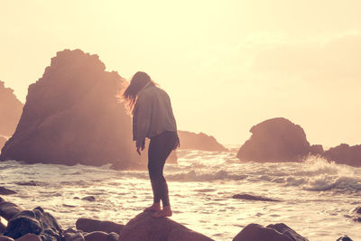 Woman on seashore at sunset