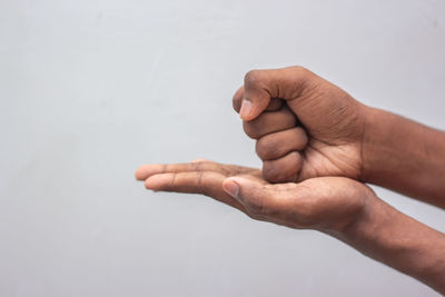 Close-up of hands over white background