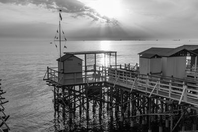 Built structure on pier over sea against sky