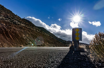 Road by mountains against blue sky