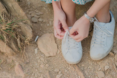 Low section of woman tying shoelace