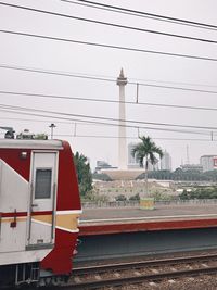 Train on railroad track in city against sky