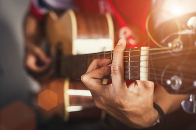 Midsection of man playing guitar