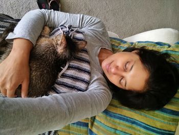 Close-up of woman with dog relaxing at home