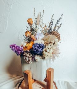 Close-up of flower vase on table against wall