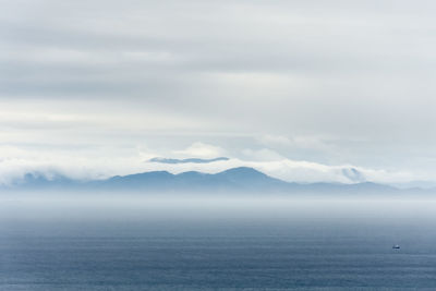 Scenic view of sea and mountains against sky