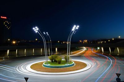 Light trails on street against sky at night