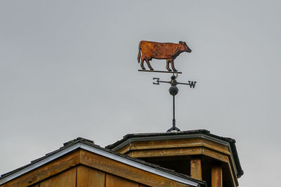 Low angle view of weather vane against clear sky