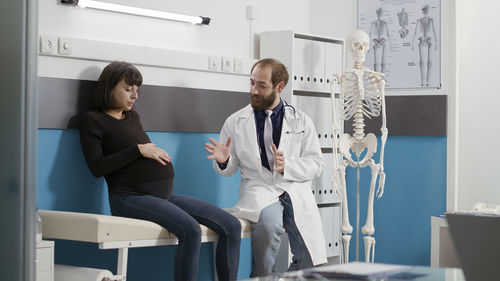 Doctor examining pregnant woman at hospital