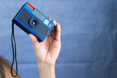 Cropped hand of person holding camera