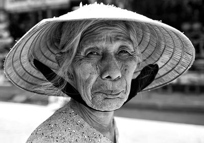 Close-up of senior woman wearing hat standing outdoors