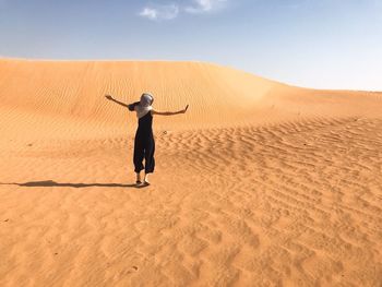 Full length rear view of man walking in desert