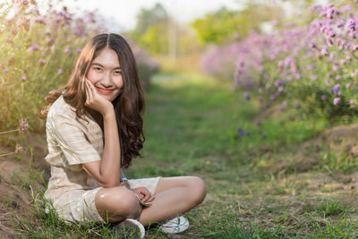 Portrait of teenage girl sitting on land