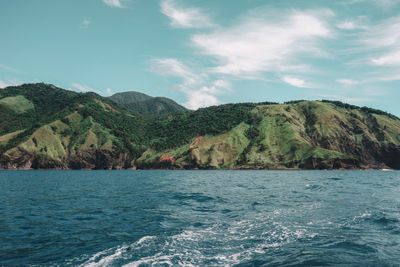 Scenic view of sea and mountains against sky