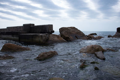 Rocks in sea against sky