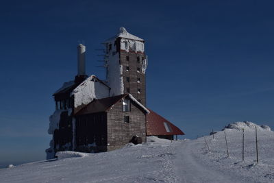 Abandoned building against sky during winter